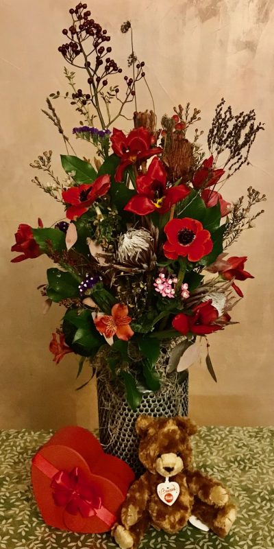 Composizione di fiori con orsetto e vaso in ceramica